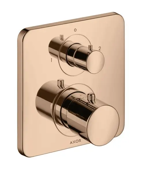 Thermostat mit zwei verchromten Reglern auf quadratischem Wandpanel in Polished Red Gold, hergestellt von AXOR. Anordnung für Ab- und Umstellventil deutlich erkennbar.